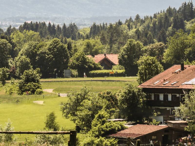 Blick von Dettenhausen Richtung Egling- ein Anwesen mit Wald und Bergpanorama im Hintergrund