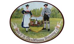Gemaltes Logo des Trachtenvereins mit einem Trachtenpaar mit einem Wappen in der Mitte, das eine Ortsansicht zeigt