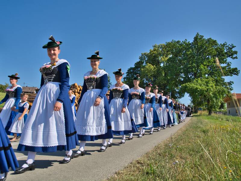 Die Thanninger Trachtlerinnen in ihrer blauen Vereinstracht mit weißer Schürze beim Kirchenzug 